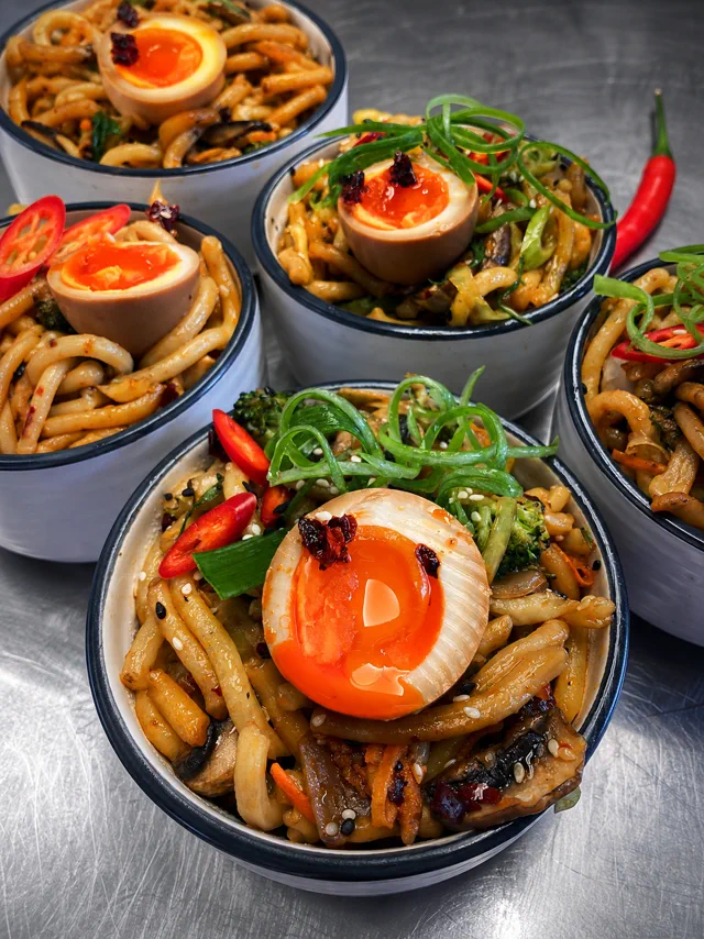 Bowls of food topped with soft eggs, greens and chillies